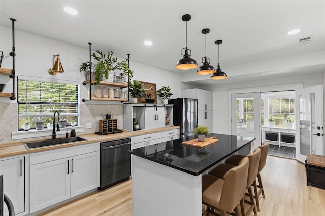 207 W River, Meridian, TX 76665 - kitchen with dishwasher, a sink, open shelves, freestanding refrigerator, and recessed lighting