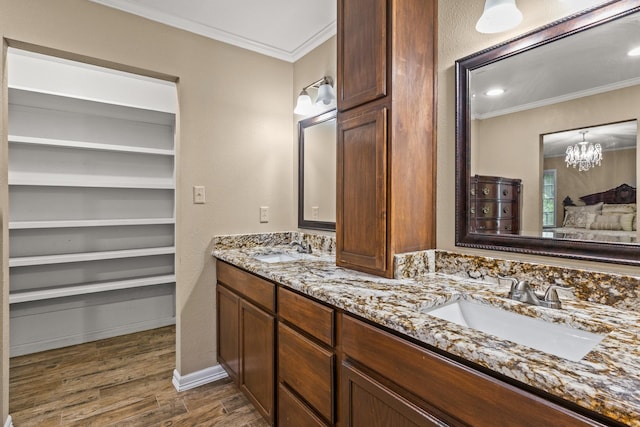 1108 Quitman St, Pittsburg, TX 75686 - bathroom with crown molding, double vanity, wood finished floors, a chandelier, and baseboards