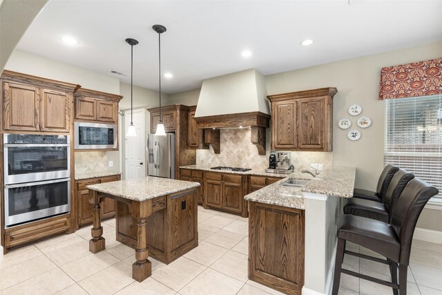 843 Bear Crossing Dr, Allen, TX 75013 - kitchen featuring appliances with stainless steel finishes, a peninsula, wall chimney exhaust hood, a kitchen breakfast bar, and a sink