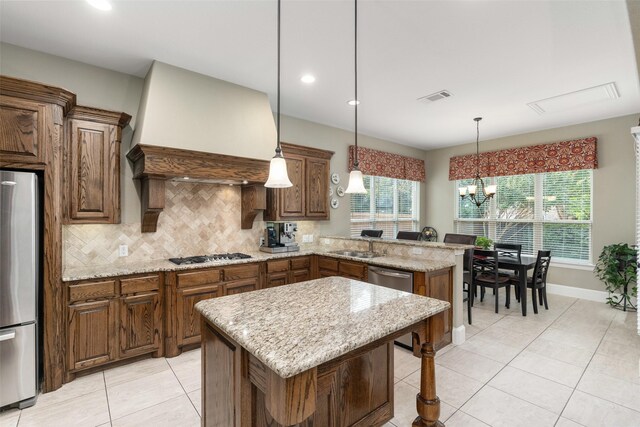 843 Bear Crossing Dr, Allen, TX 75013 - kitchen with appliances with stainless steel finishes, a peninsula, light tile patterned flooring, a chandelier, and tasteful backsplash