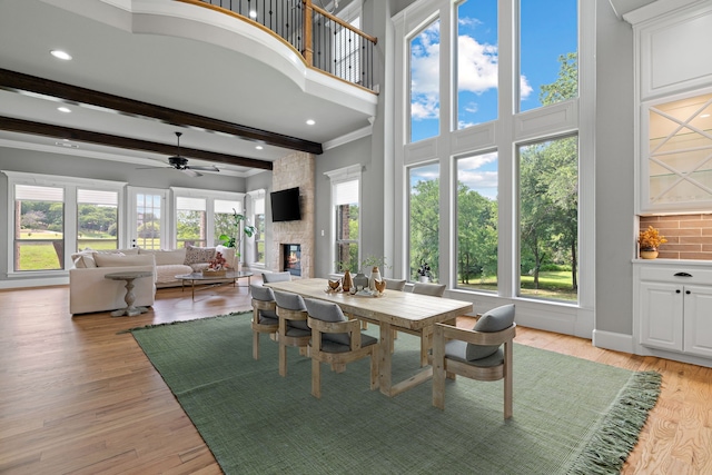 1803 Sunset Xing, Cedar Hill, TX 75104 - dining room featuring a fireplace, a towering ceiling, beam ceiling, a ceiling fan, and crown molding