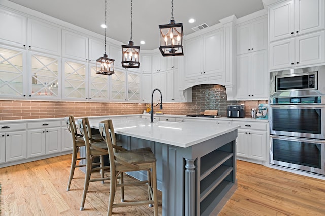 1803 Sunset Xing, Cedar Hill, TX 75104 - kitchen featuring white cabinets, a kitchen island with sink, light countertops, stainless steel appliances, and recessed lighting