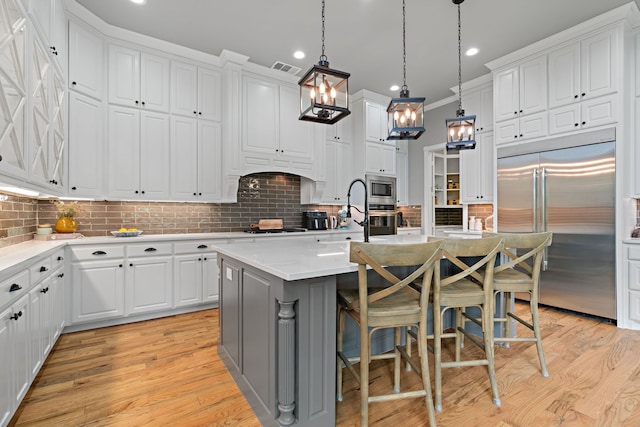 1803 Sunset Xing, Cedar Hill, TX 75104 - kitchen featuring built in appliances, a sink, light wood finished floors, an island with sink, and recessed lighting