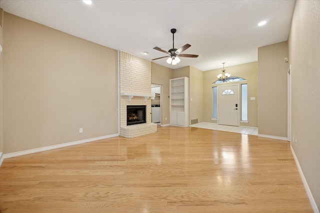 6404 Westgate Dr, North Richland Hills, TX 76182 - unfurnished living room featuring light wood-style flooring, ceiling fan, a chandelier, a brick fireplace, and recessed lighting