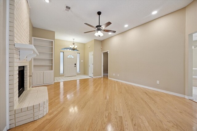 6404 Westgate Dr, North Richland Hills, TX 76182 - unfurnished living room with ceiling fan, a brick fireplace, light wood finished floors, a chandelier, and recessed lighting