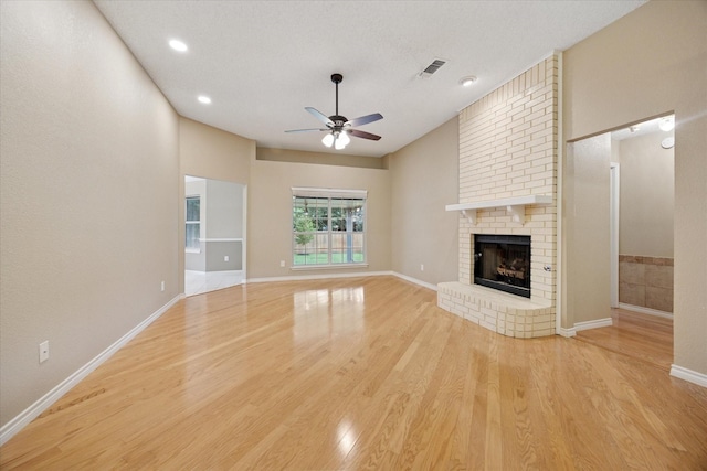 6404 Westgate Dr, North Richland Hills, TX 76182 - unfurnished living room featuring a ceiling fan, light wood-style flooring, a fireplace, and recessed lighting