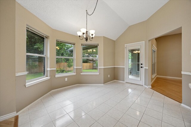 6404 Westgate Dr, North Richland Hills, TX 76182 - unfurnished dining area featuring a chandelier, tile patterned floors, plenty of natural light, lofted ceiling, and a textured ceiling