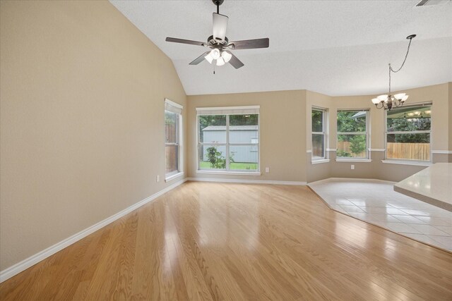 6404 Westgate Dr, North Richland Hills, TX 76182 - unfurnished living room featuring a chandelier, healthy amount of natural light, light wood finished floors, vaulted ceiling, and ceiling fan