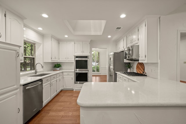 1535 Windsor Forest Trl, Keller, TX 76262 - kitchen featuring appliances with stainless steel finishes, a peninsula, white cabinets, and recessed lighting