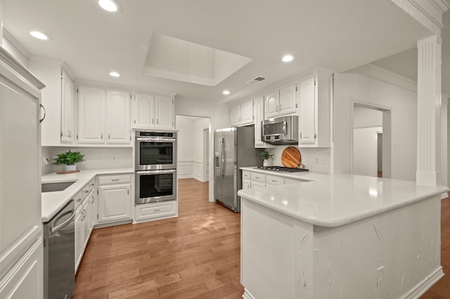 1535 Windsor Forest Trl, Keller, TX 76262 - kitchen featuring stainless steel appliances, crown molding, a peninsula, decorative backsplash, and white cabinets