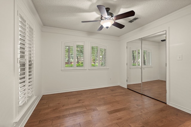 1535 Windsor Forest Trl, Keller, TX 76262 - unfurnished bedroom featuring wood-type flooring, a textured ceiling, a closet, crown molding, and ceiling fan