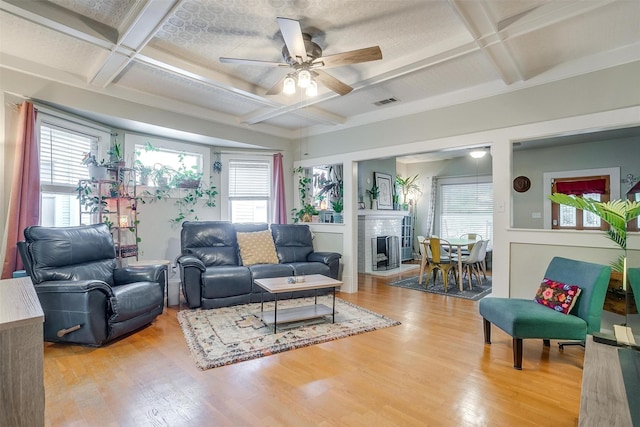 2108 Fairmount Ave, Fort Worth, TX 76110 - living area with coffered ceiling, a ceiling fan, light wood finished floors, beam ceiling, and a brick fireplace