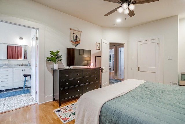 2108 Fairmount Ave, Fort Worth, TX 76110 - bedroom with light wood finished floors, a sink, ensuite bath, baseboards, and a ceiling fan