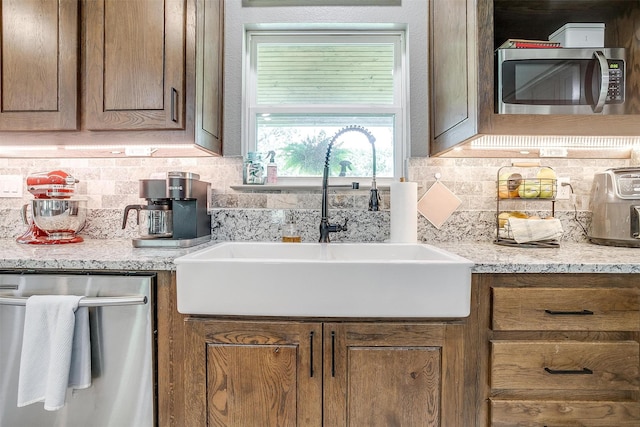 1107 Perkins Rd, Poolville, TX 76487 - kitchen featuring appliances with stainless steel finishes, a sink, and decorative backsplash