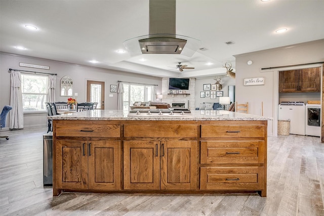 1107 Perkins Rd, Poolville, TX 76487 - kitchen featuring a tray ceiling, separate washer and dryer, island range hood, ornamental molding, and ceiling fan