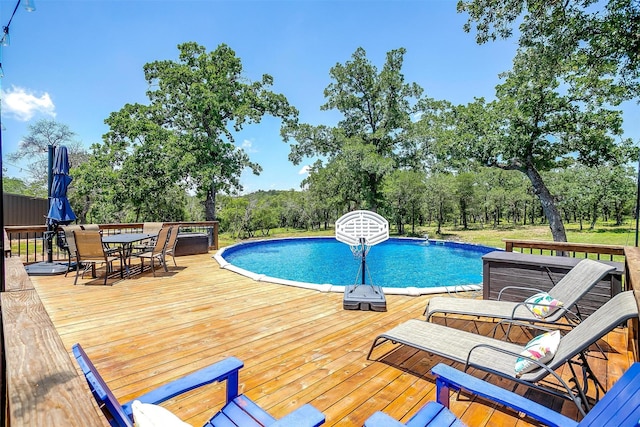 1107 Perkins Rd, Poolville, TX 76487 - outdoor pool with a wooden deck, outdoor dining area, and view of wooded area