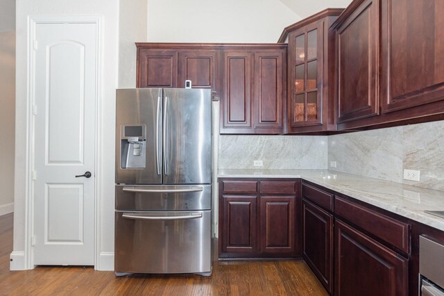 1416 Tangle Ridge Dr, Mckinney, TX 75071 - kitchen featuring stainless steel refrigerator with ice dispenser, backsplash, dark wood-style flooring, light stone counters, and glass insert cabinets