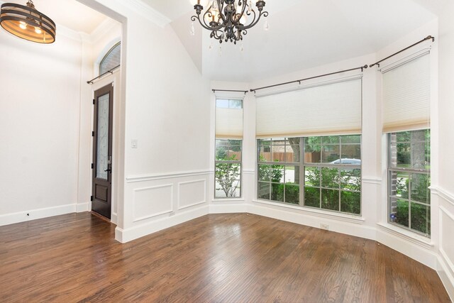 1416 Tangle Ridge Dr, Mckinney, TX 75071 - spare room featuring healthy amount of natural light, a chandelier, wood finished floors, crown molding, and a decorative wall
