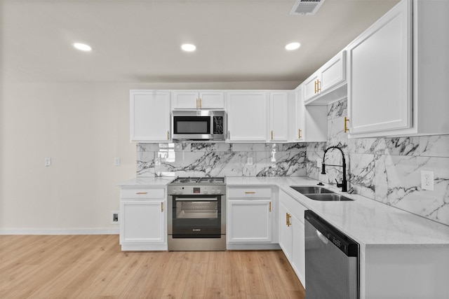 2634 Macon St, Dallas, TX 75215 - kitchen featuring stainless steel appliances, white cabinetry, tasteful backsplash, light stone counters, and recessed lighting