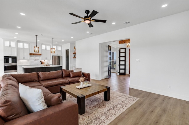 2418 Spirit Ct, Tolar, TX 76476 - living area featuring recessed lighting, light wood-type flooring, ceiling fan, baseboards, and a chandelier
