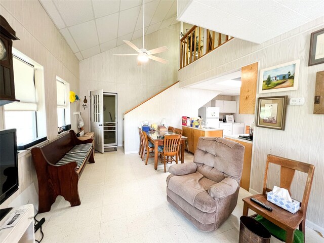 5260 County Road 268, Anson, TX 79501 - living area with washer / dryer, a ceiling fan, light floors, high vaulted ceiling, and wood walls