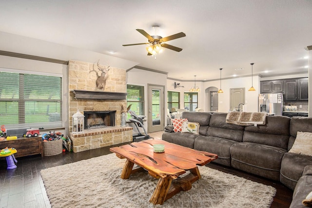 407 Dill Rd, Weatherford, TX 76085 - living room with ornamental molding, a ceiling fan, dark wood finished floors, and a stone fireplace
