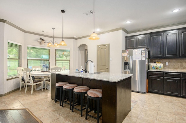 407 Dill Rd, Weatherford, TX 76085 - kitchen with stainless steel fridge with ice dispenser, a kitchen bar, light stone countertops, crown molding, and plenty of natural light