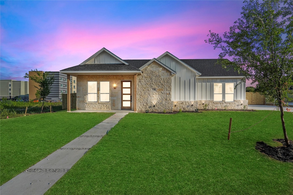 1222 Gannon Ln, Desoto, TX 75115 - view of front of home with board and batten siding, stone siding, a front yard, and a shingled roof