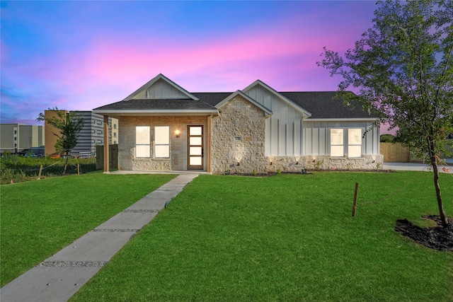 1222 Gannon Ln, Desoto, TX 75115 - view of front of home with board and batten siding, stone siding, a front yard, and a shingled roof