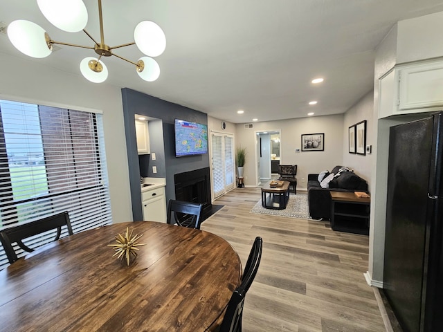 5913 Lake Hubbard Pkwy Unit 124, Garland, TX 75043 - dining room with a chandelier, light wood-style flooring, recessed lighting, a fireplace with flush hearth, and baseboards