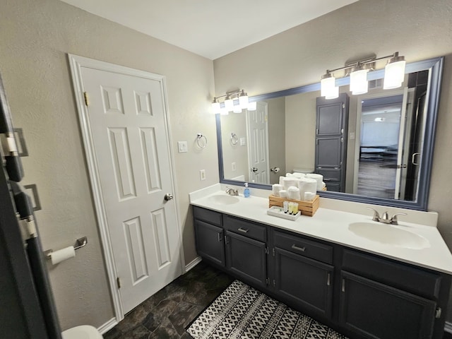 5913 Lake Hubbard Pkwy Unit 124, Garland, TX 75043 - bathroom featuring double vanity, baseboards, and stone finish floors