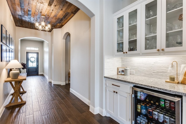 2921 Crossbow Ln, Celina, TX 75009 - indoor bar with arched walkways, wine cooler, wooden ceiling, baseboards, and decorative backsplash