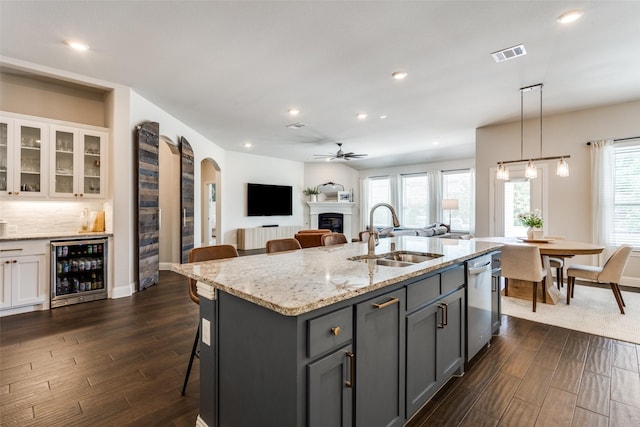 2921 Crossbow Ln, Celina, TX 75009 - kitchen with a sink, wine cooler, dishwasher, a ceiling fan, and a glass covered fireplace