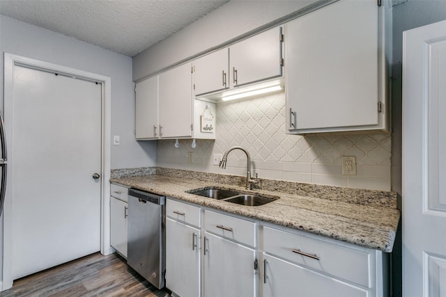 649 Timberline Dr, Hurst, TX 76053 - kitchen featuring stainless steel dishwasher, a sink, decorative backsplash, wood finished floors, and white cabinetry