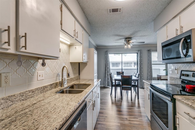 649 Timberline Dr, Hurst, TX 76053 - kitchen featuring appliances with stainless steel finishes, a sink, a textured ceiling, dark wood-style floors, and ceiling fan