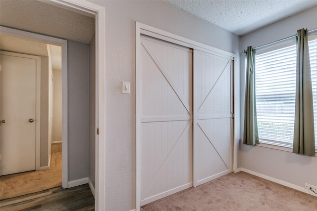 649 Timberline Dr, Hurst, TX 76053 - unfurnished bedroom with a closet, a textured ceiling, carpet floors, and baseboards