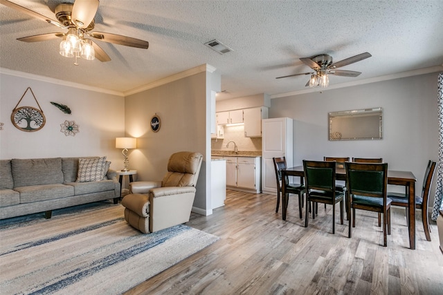 649 Timberline Dr, Hurst, TX 76053 - living room with ceiling fan, light wood-type flooring, ornamental molding, and a textured ceiling