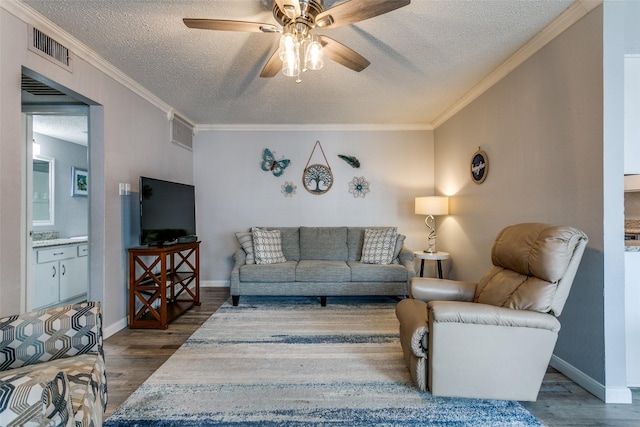 649 Timberline Dr, Hurst, TX 76053 - living room with dark wood-style flooring, a textured ceiling, ceiling fan, crown molding, and baseboards