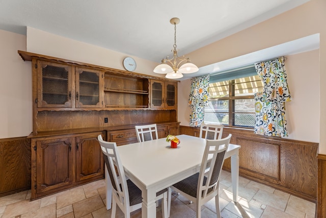 208 Ashe Bend Dr, Rowlett, TX 75087 - dining area with a chandelier, wainscoting, and light stone finish floors