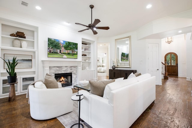 1331 Crockett Dr, Frisco, TX 75033 - living area featuring a lit fireplace, built in features, ceiling fan, ornamental molding, and dark wood-style floors