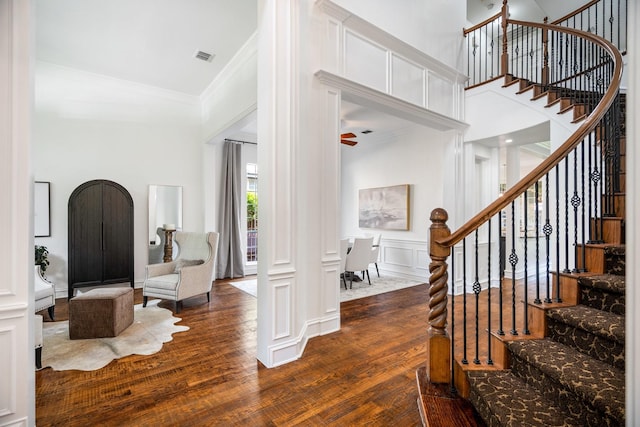 1331 Crockett Dr, Frisco, TX 75033 - foyer featuring dark wood finished floors, a decorative wall, stairs, ornamental molding, and a ceiling fan