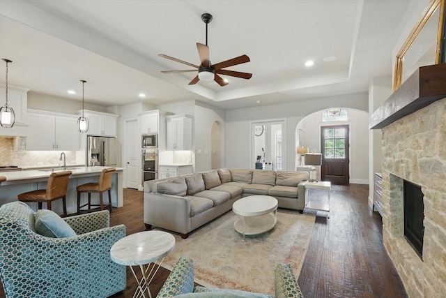 125 Chisholm Trl, Highland Village, TX 75077 - living area featuring arched walkways, dark wood-style floors, a ceiling fan, a fireplace, and recessed lighting