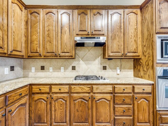 3604 Camino Trl, Mckinney, TX 75070 - kitchen featuring under cabinet range hood, stainless steel appliances, and brown cabinetry