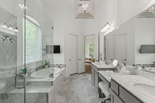 10933 Smoky Oak Trl, Flower Mound, TX 76226 - full bathroom featuring double vanity, a bath, a stall shower, marble finish flooring, and a high ceiling