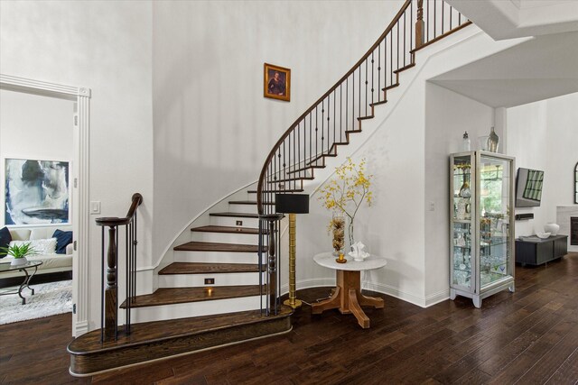 10933 Smoky Oak Trl, Flower Mound, TX 76226 - stairs featuring a towering ceiling, hardwood / wood-style floors, and baseboards