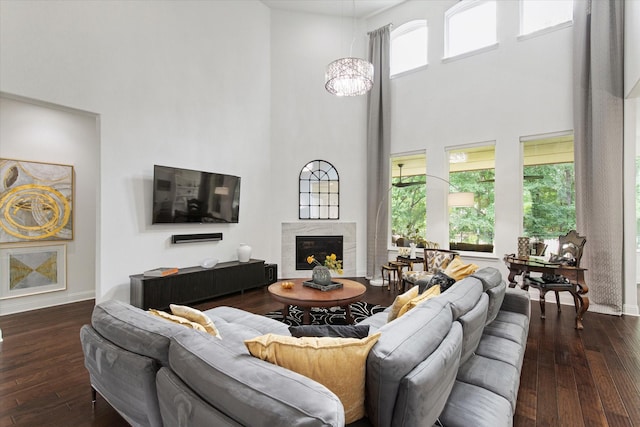 10933 Smoky Oak Trl, Flower Mound, TX 76226 - living area featuring a towering ceiling, dark wood-type flooring, a premium fireplace, and baseboards