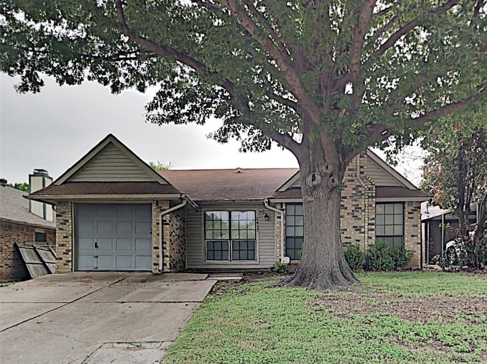 2417 Busch Dr, Arlington, TX 76014 - view of front of home featuring a garage, concrete driveway, and brick siding