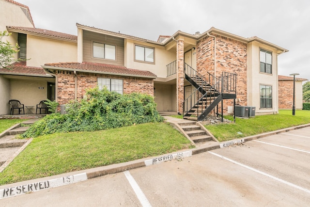 920 Turtle Cv Unit 252, Irving, TX 75060 - townhome / multi-family property with uncovered parking, stairway, stucco siding, and a front lawn