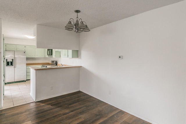 920 Turtle Cv Unit 252, Irving, TX 75060 - unfurnished dining area featuring a chandelier, dark wood finished floors, a textured ceiling, and baseboards