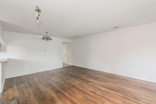 920 Turtle Cv Unit 252, Irving, TX 75060 - unfurnished room with wood finished floors, a chandelier, a textured ceiling, and rail lighting